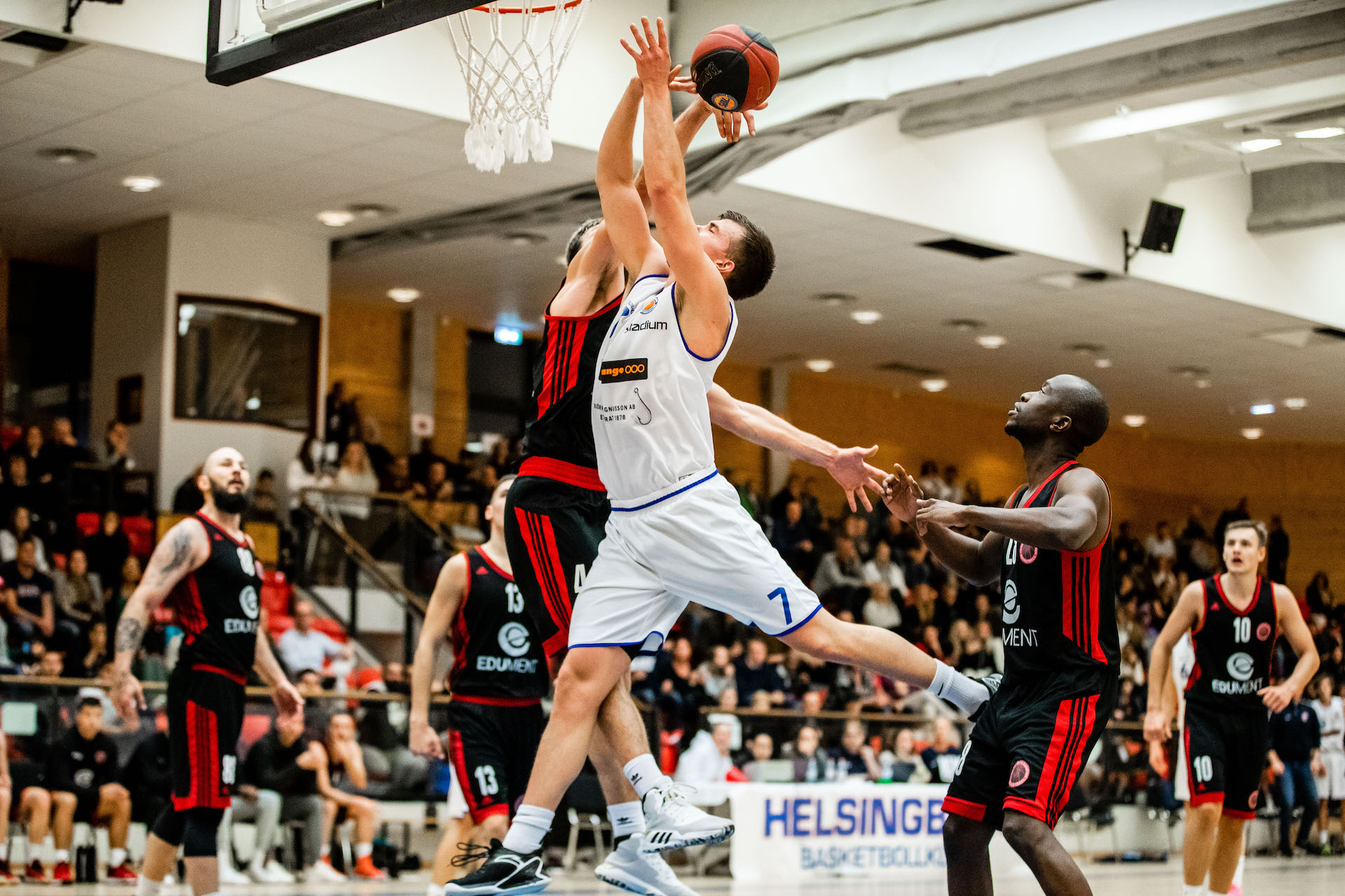 Två killar i bild som spelar basket, en försöker blocka. Superettan i basket.